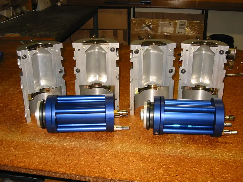 Finished machined metal assemblies laid out on a workbench